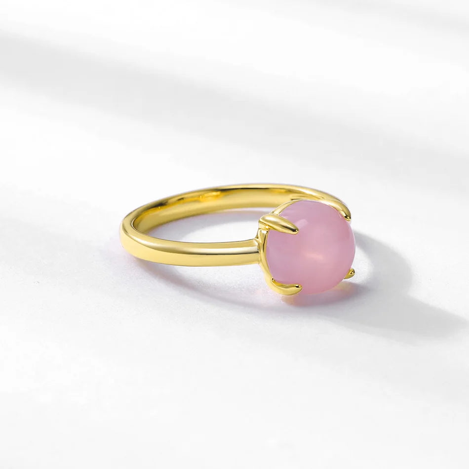 Bague en or avec pierre de quartz rose, présentée sur fond blanc lumineux.