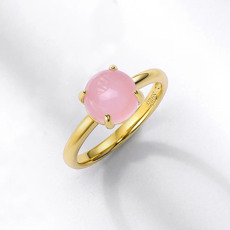 Bague en or avec pierre de quartz rose sur fond blanc, présentée pour la vente.